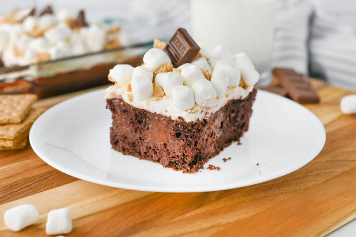An up close look at smores poke cake with Hershey chocolate and marshmallows on top.