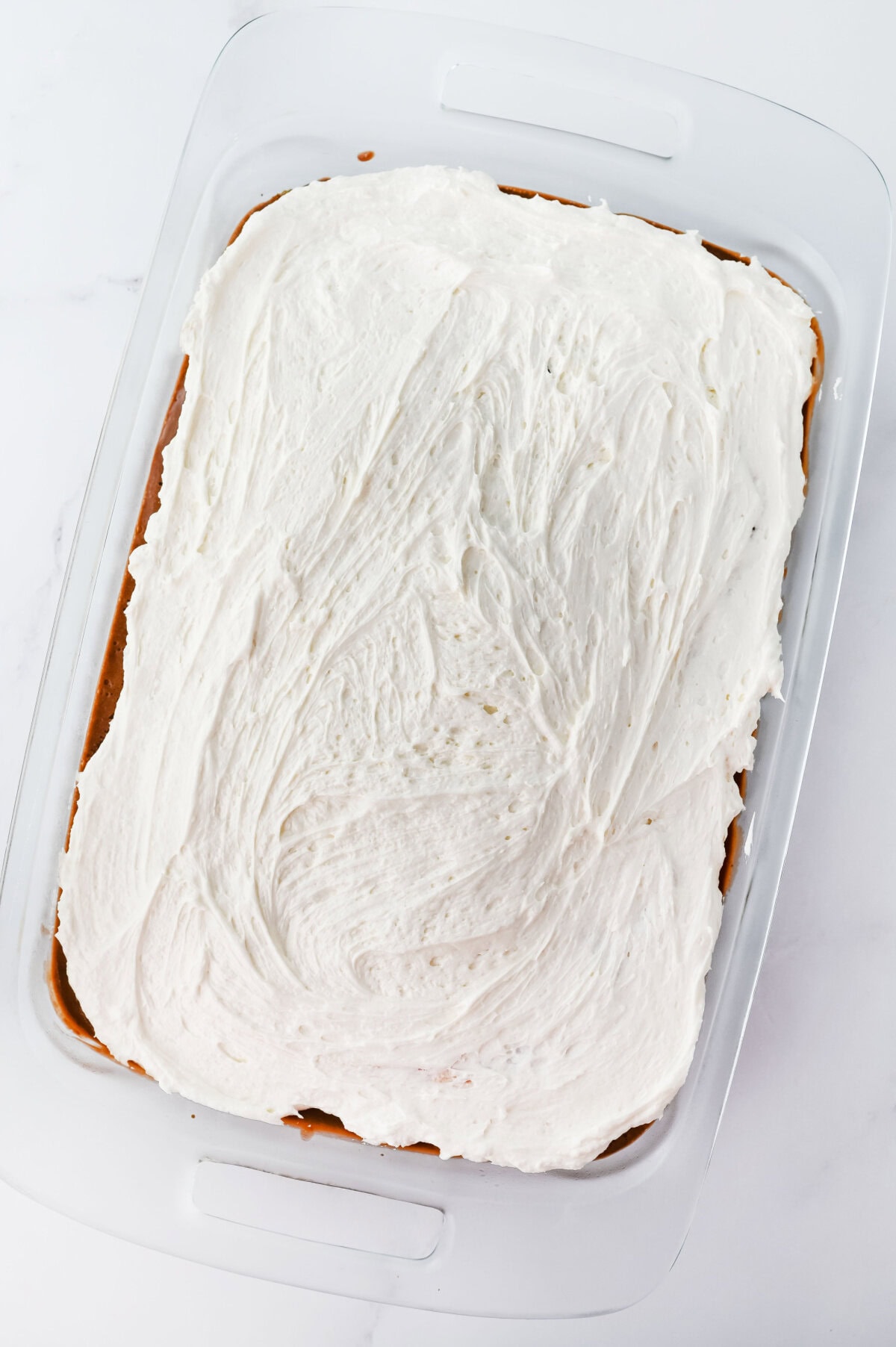 Marshmallow creme frosting spread evenly on top of chocolate pudding.