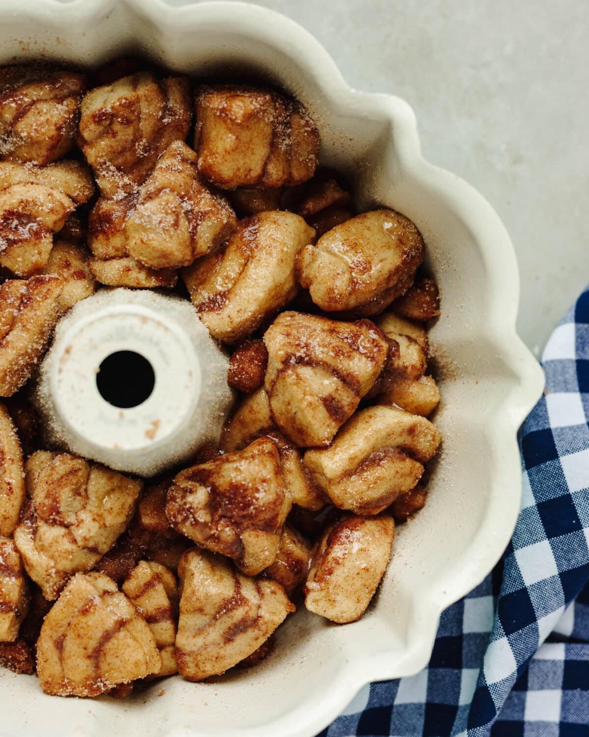 Sliced cinnamon rolls in a bundt pan with cinnamon sugar.