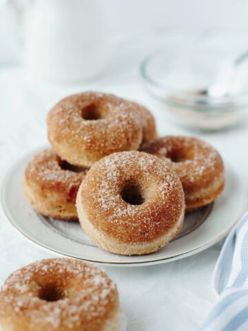 Baked cinnamon sugar donuts on a white plate.