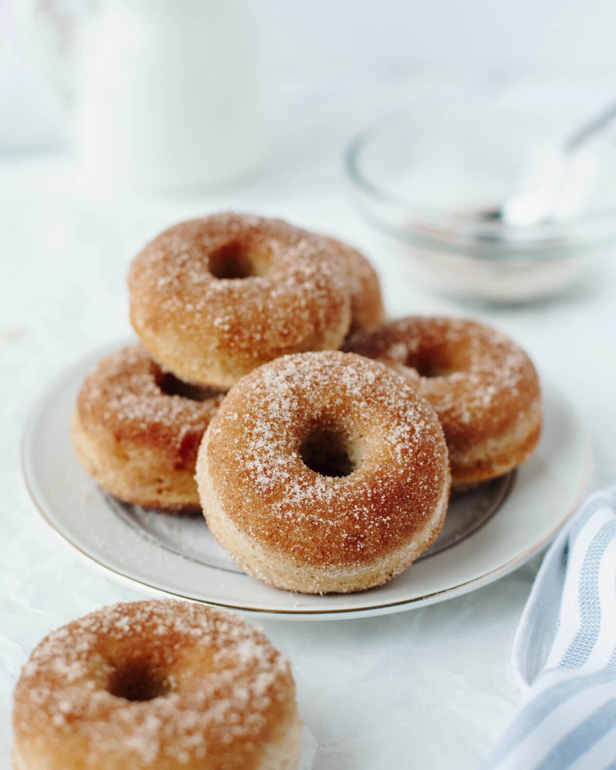 Baked cinnamon sugar donuts on a white plate.