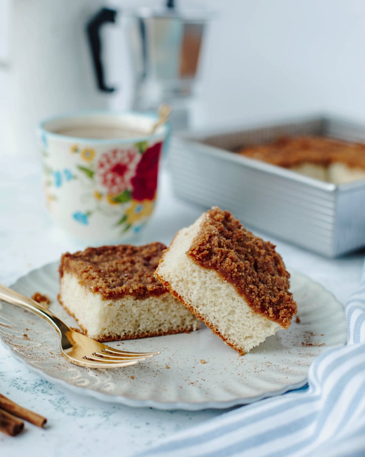 Two slices of Bisquick coffee cake served on a white plate with a frok.