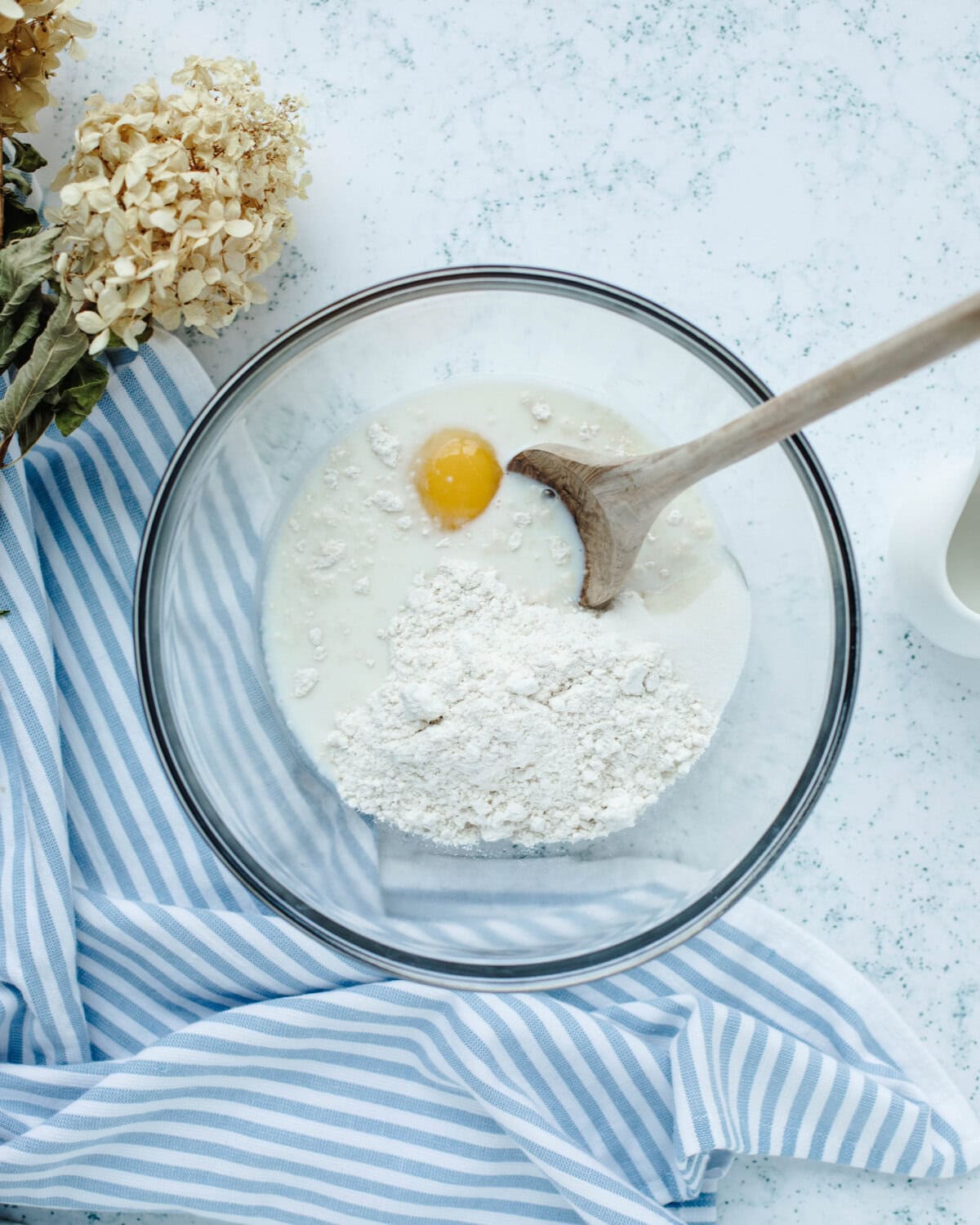 Bisquick, milk, egg, and sugar combined in a glass bowl.