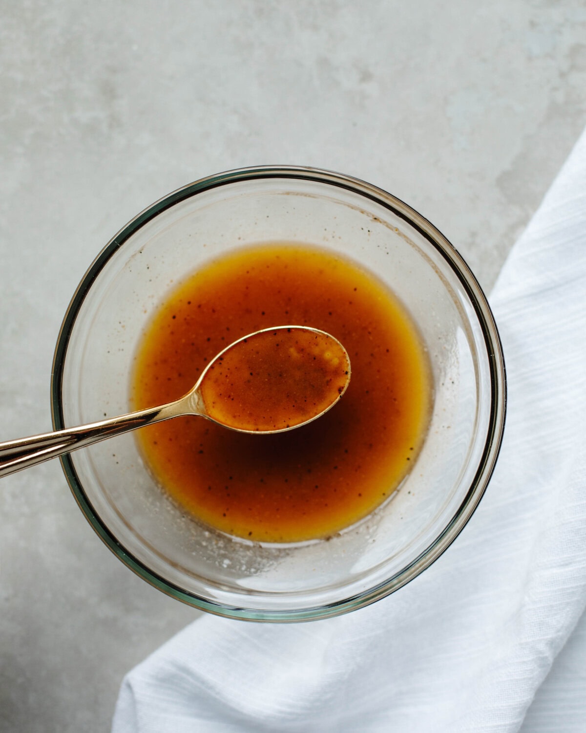 Cajun seasoning, garlic, and olive oil combined in a glass mixing bowl.