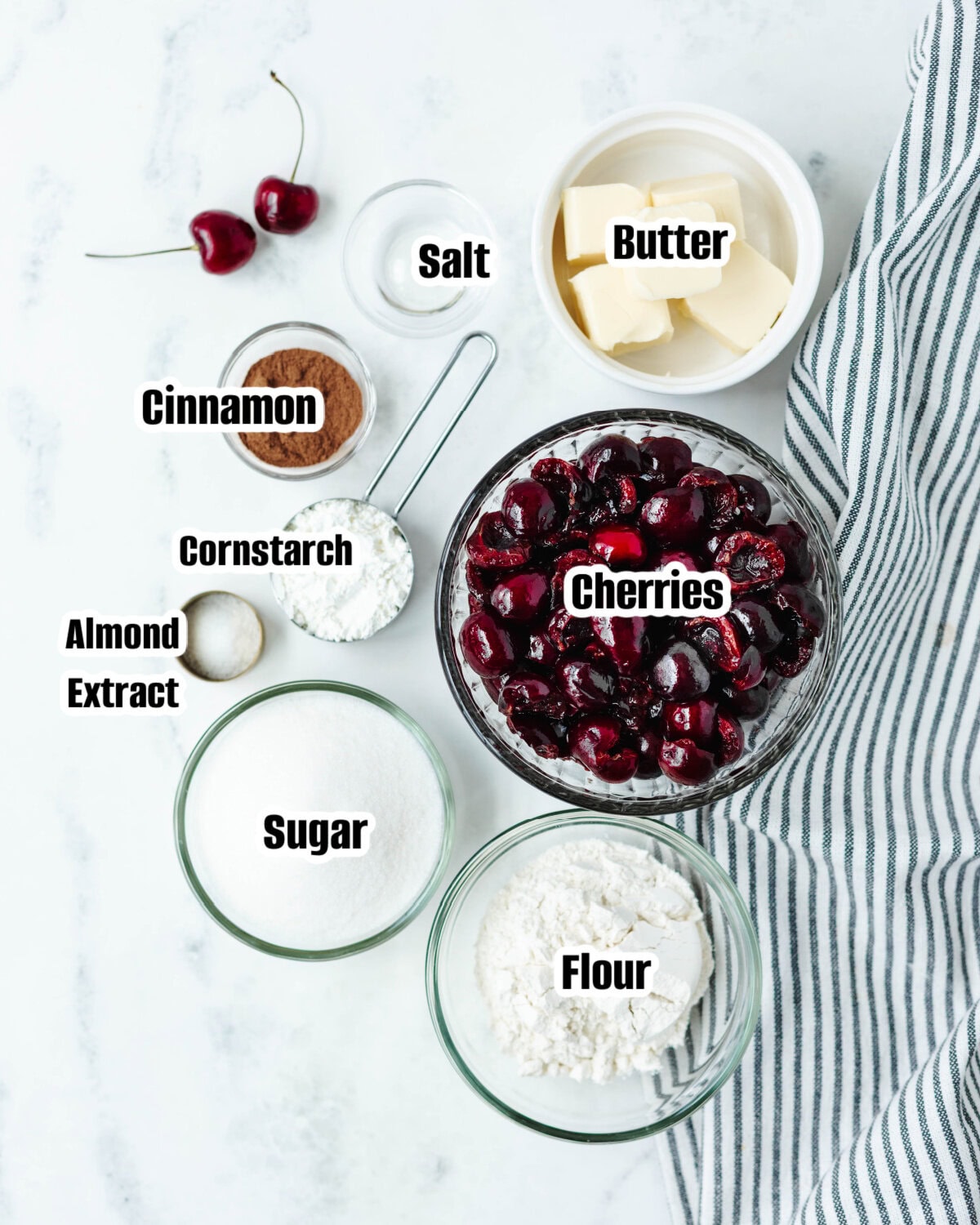 All the ingredients needed to make a cherry cobbler in a skillet.