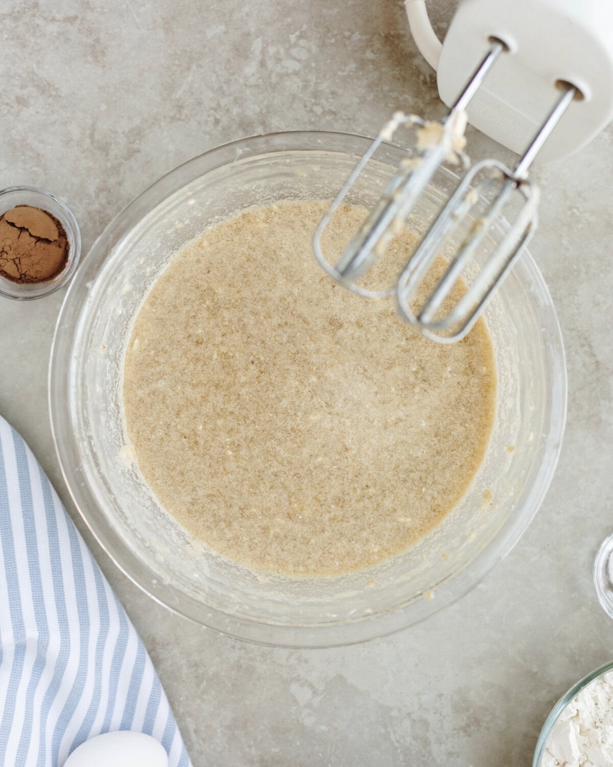 Eggs folded into a cake batter mixture using electric hand mixer.