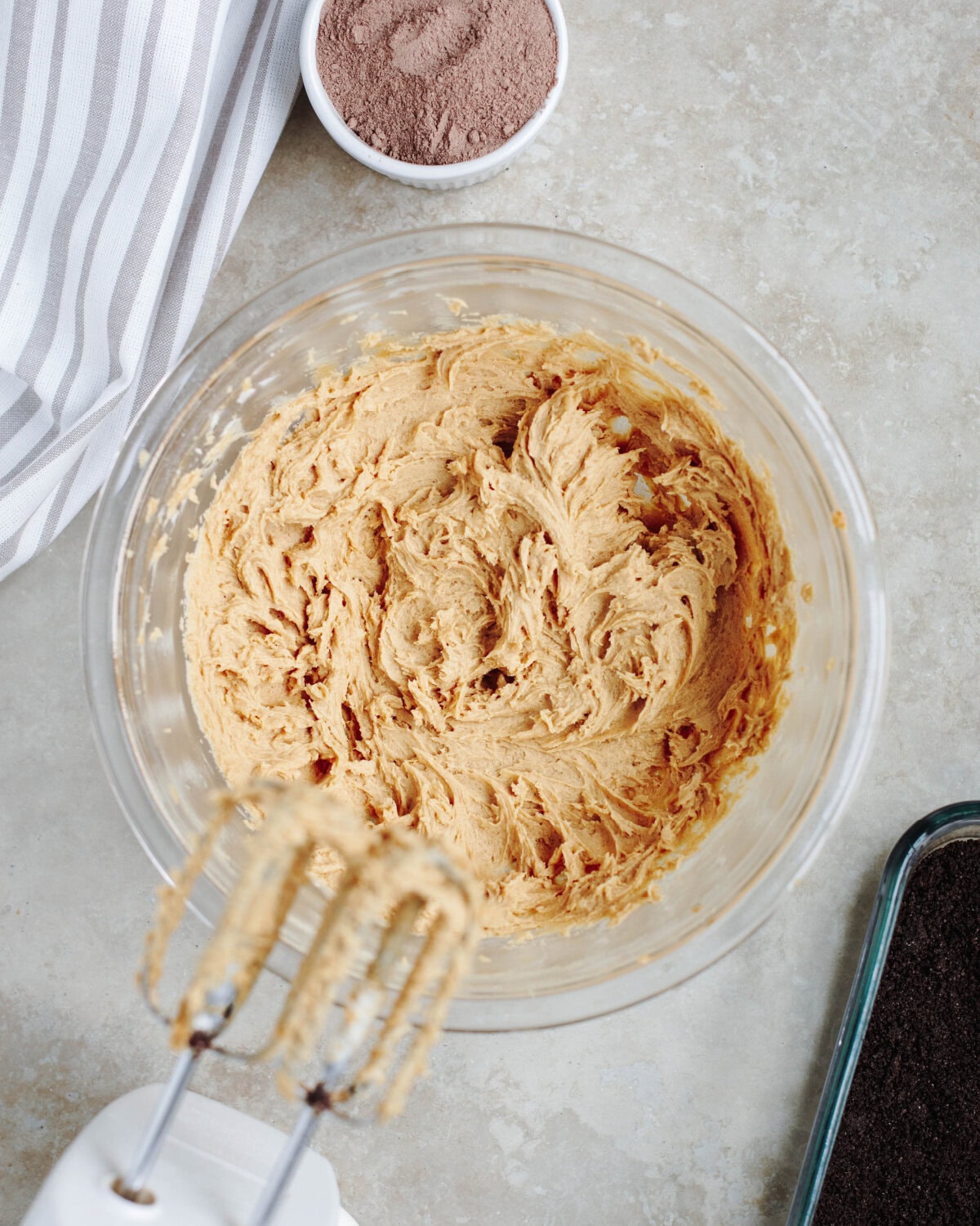 Cream cheese, peanut butter, and powdered sugar combined in a glass bowl.