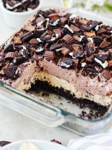 A side view showing the layers of Oreo crumbs, peanut butter cream cheese, instant chocolate pudding mix, and Reese's.