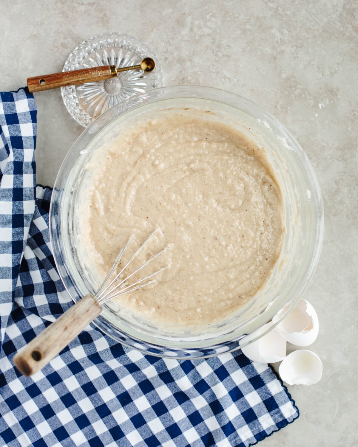 Batter combined using a whisk in a glass mixing bowl.