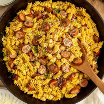 Creamy Cajun sausage pasta in a cast iron skillet.