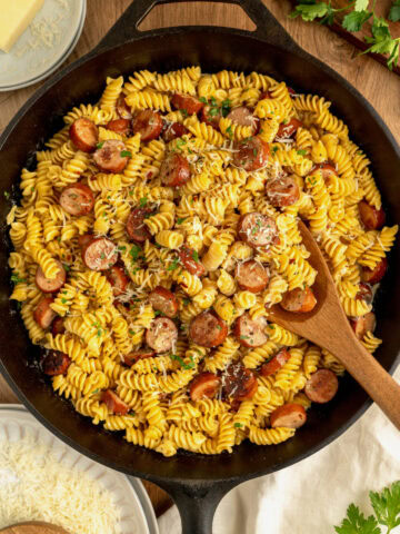 Creamy Cajun sausage pasta in a cast iron skillet.