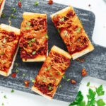 Slices of sloppy joes on garlic bread ready to serve.