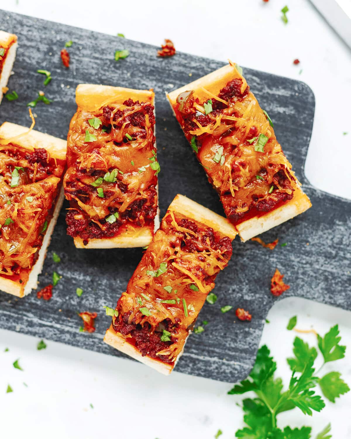 Slices of sloppy joes on garlic bread ready to serve.