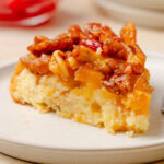 Slice of Pineapple Upside Down Cake showing the soft cake, caramelized pineapple, and walnut topping.