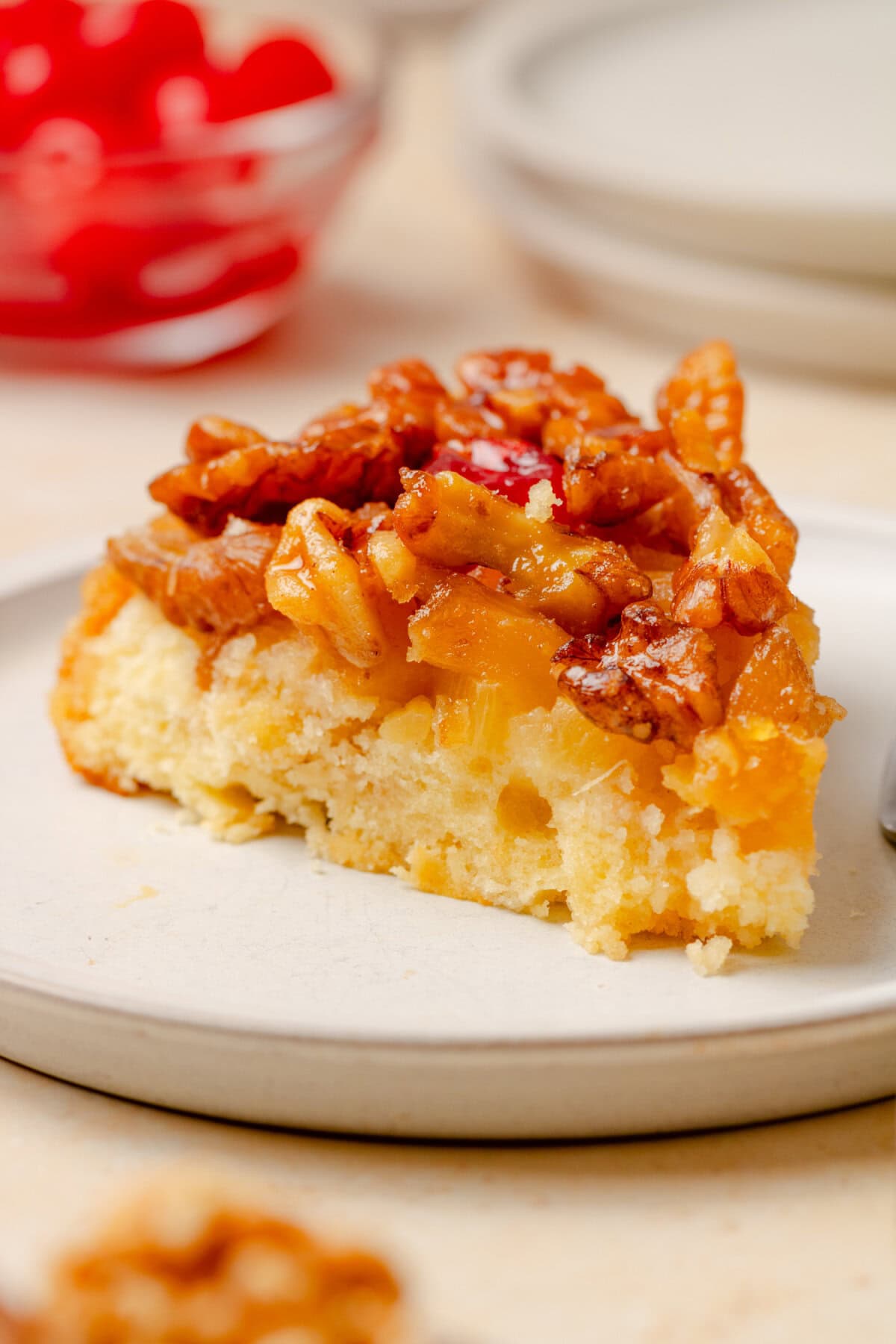 Slice of Pineapple Upside Down Cake showing the soft cake, caramelized pineapple, and walnut topping.
