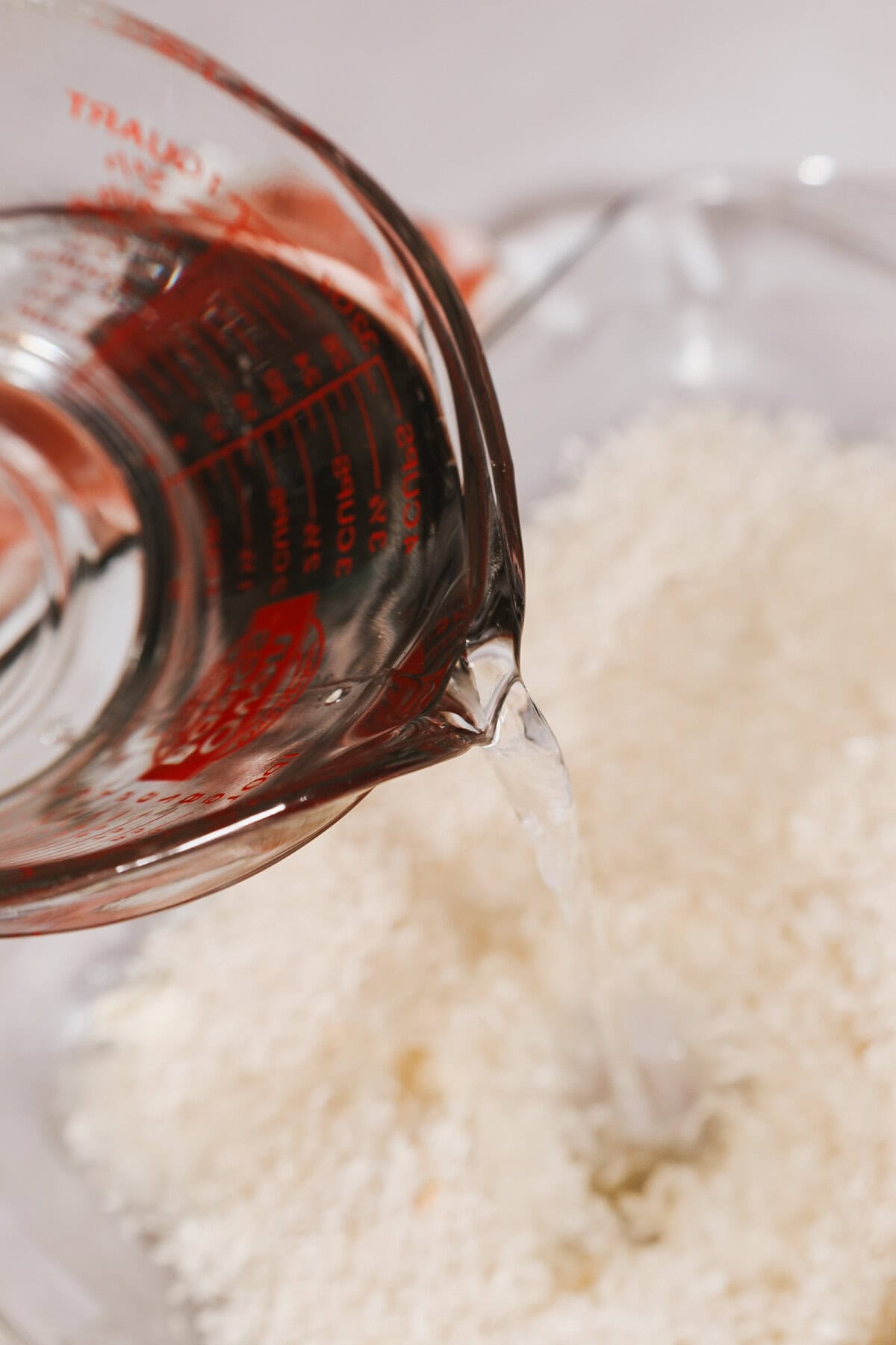 Water poured over rice in a baking pan.