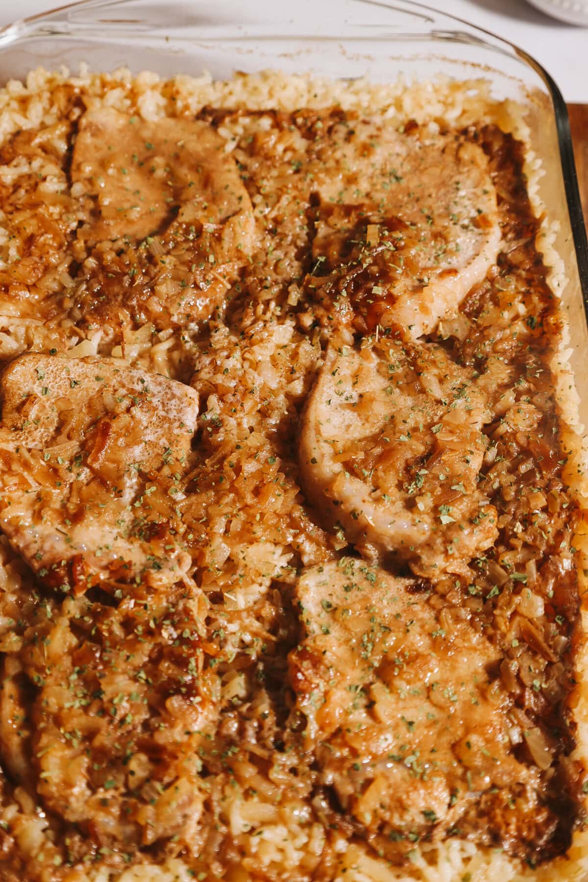Cooked pork chops and rice casserole in a glass 9x13 baking pan.