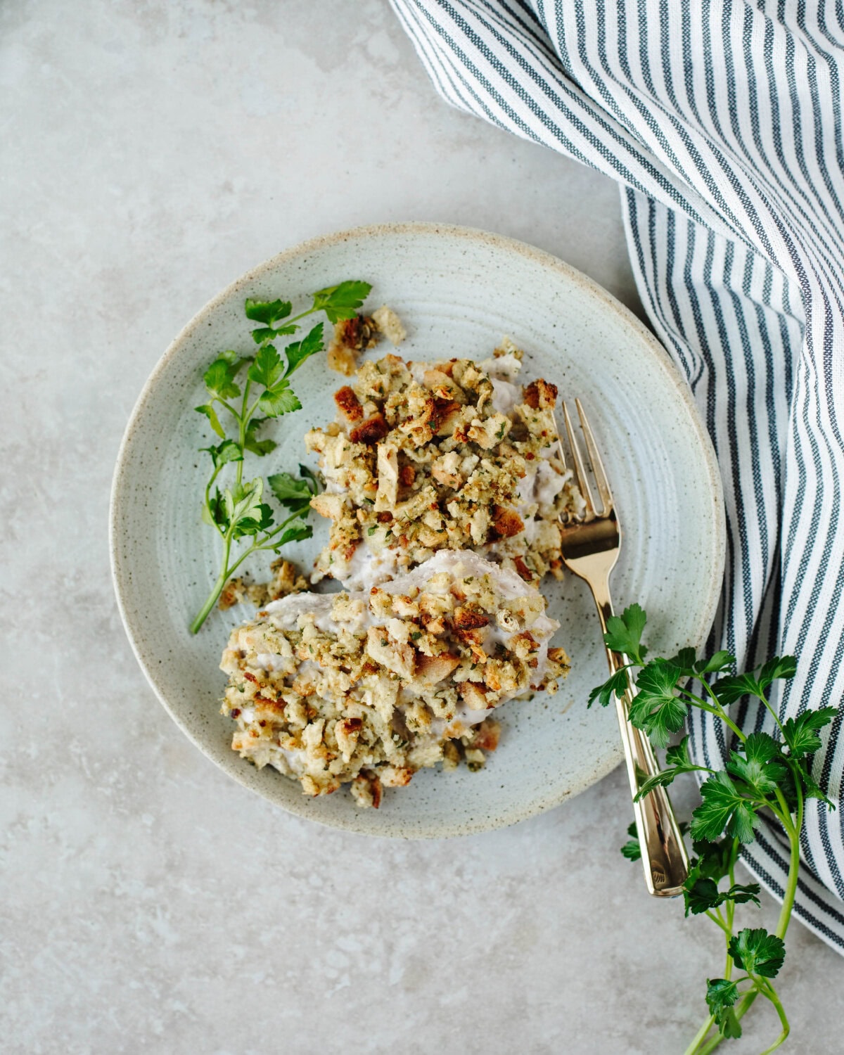 Baked pork chops with stuffing served on a plate.