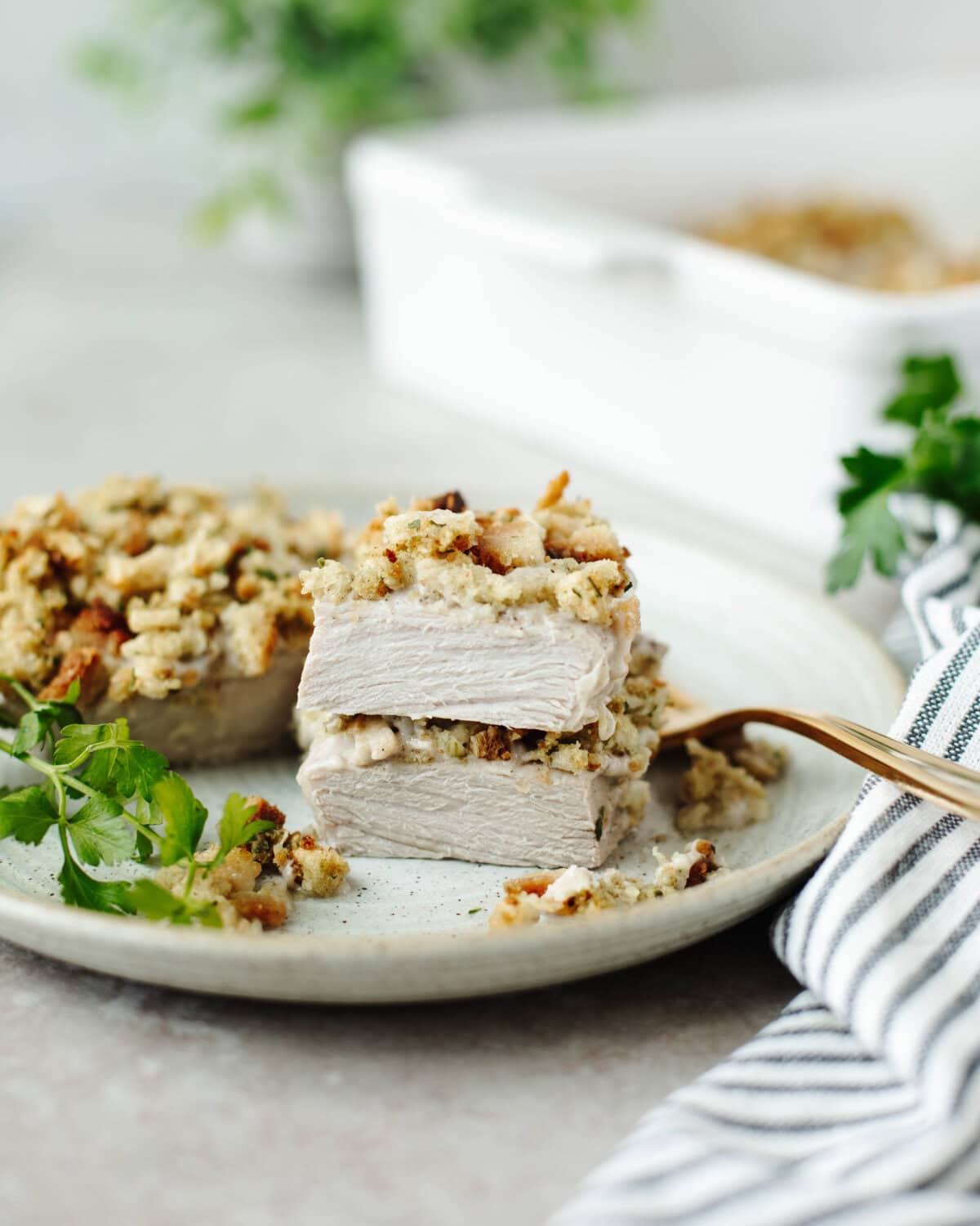 A slice pork chop showing the moist, tender center while served on a dinner plate.