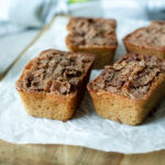Mini loaves of snickerdoodle apple quick bread on a wood cutting board.