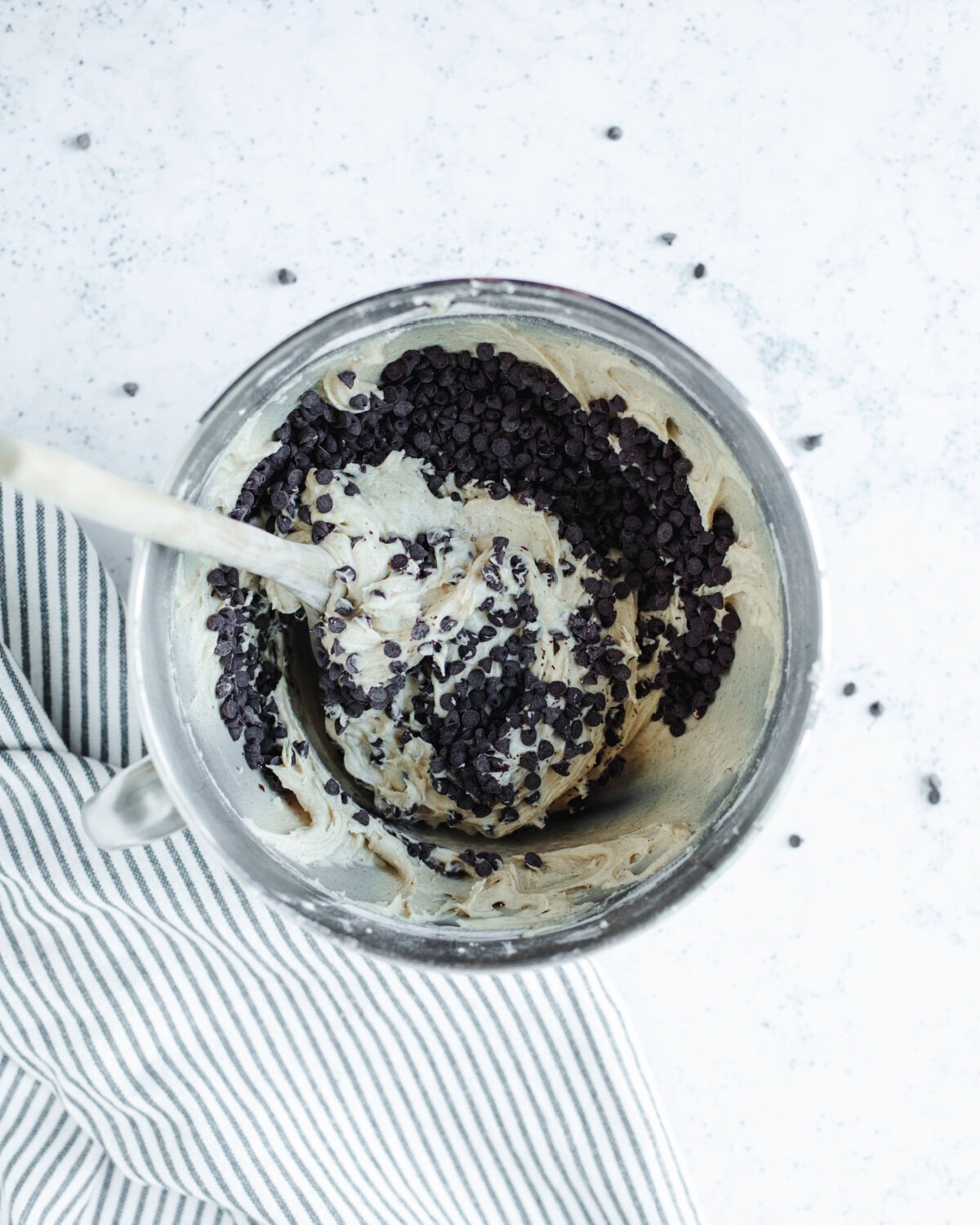 Mini chocolate chips folded into batter in a mixing bowl.
