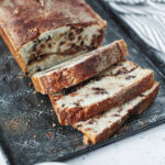 Baked loaf of snickerdoodle bread sliced and ready to serve from a serving tray.