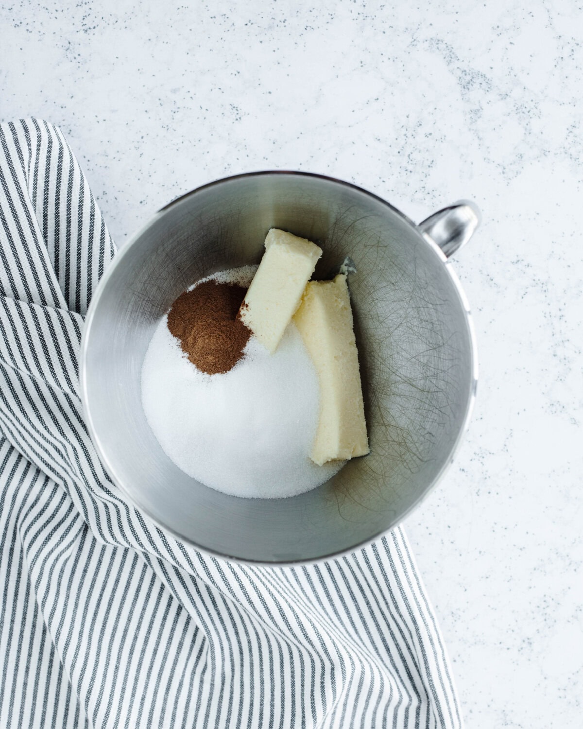 Creamed butter, sugar, salt, and cinnamon in a mixing bowl.