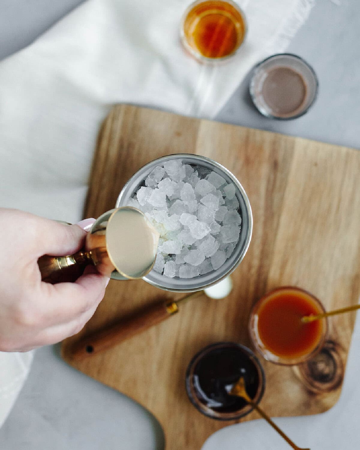 Baileys Irish Cream poured into an ice filled cocktail shaker.