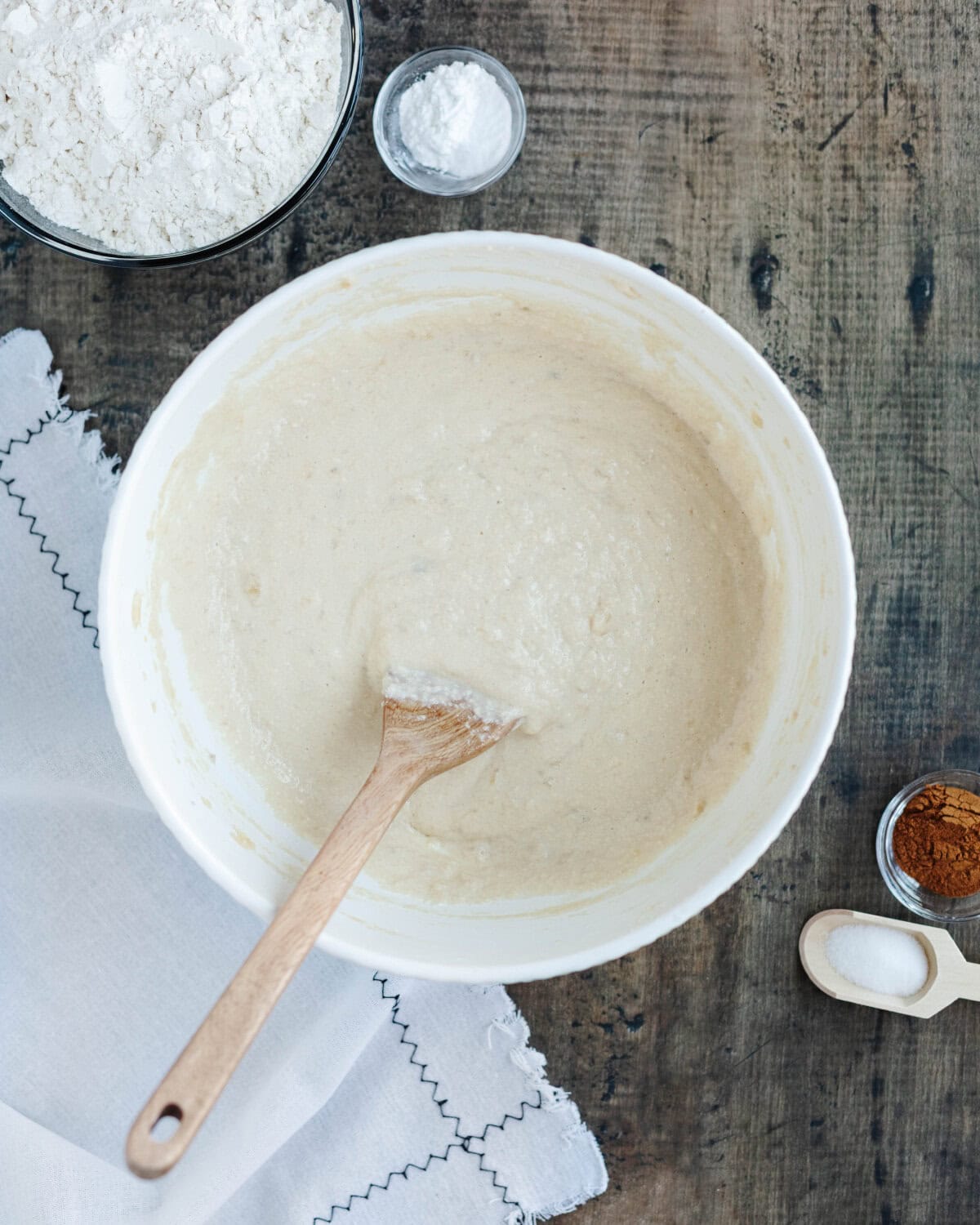 Wet batter prepared in a mixing bowl to make a banana cake.