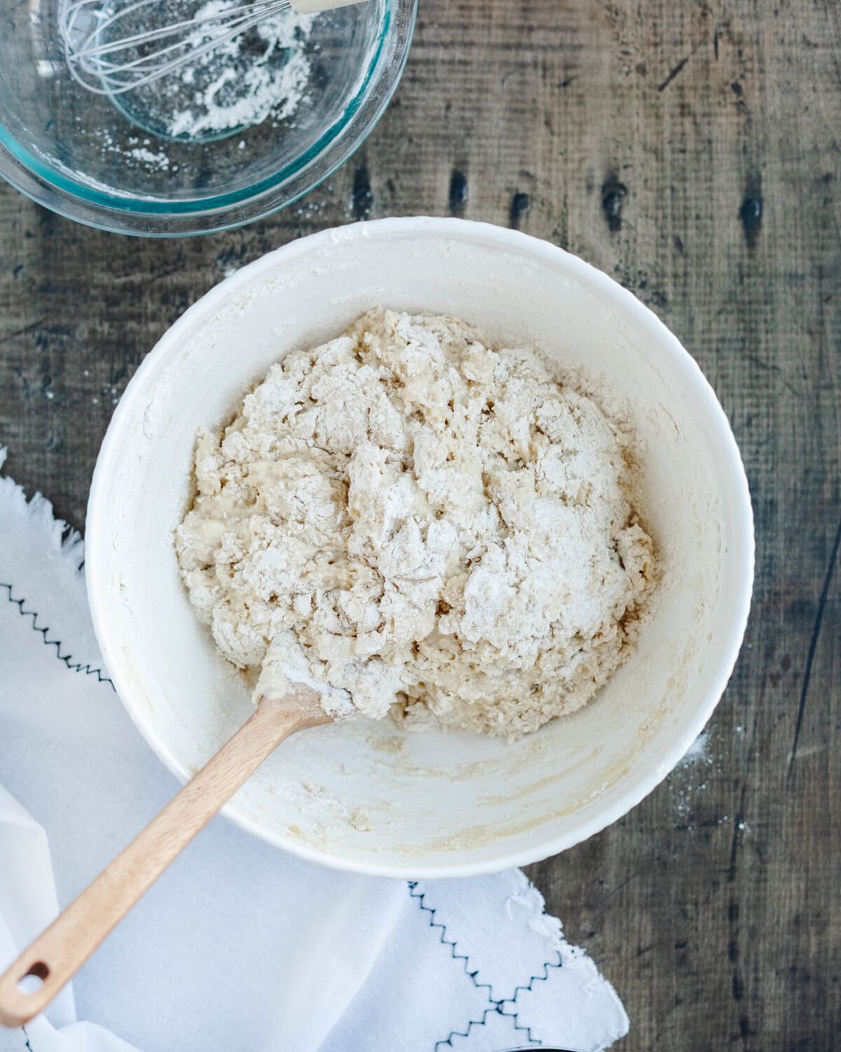 Flour, salt, baking powder, and baking soda folded into a butter and sugar mixture in a mixing bowl.