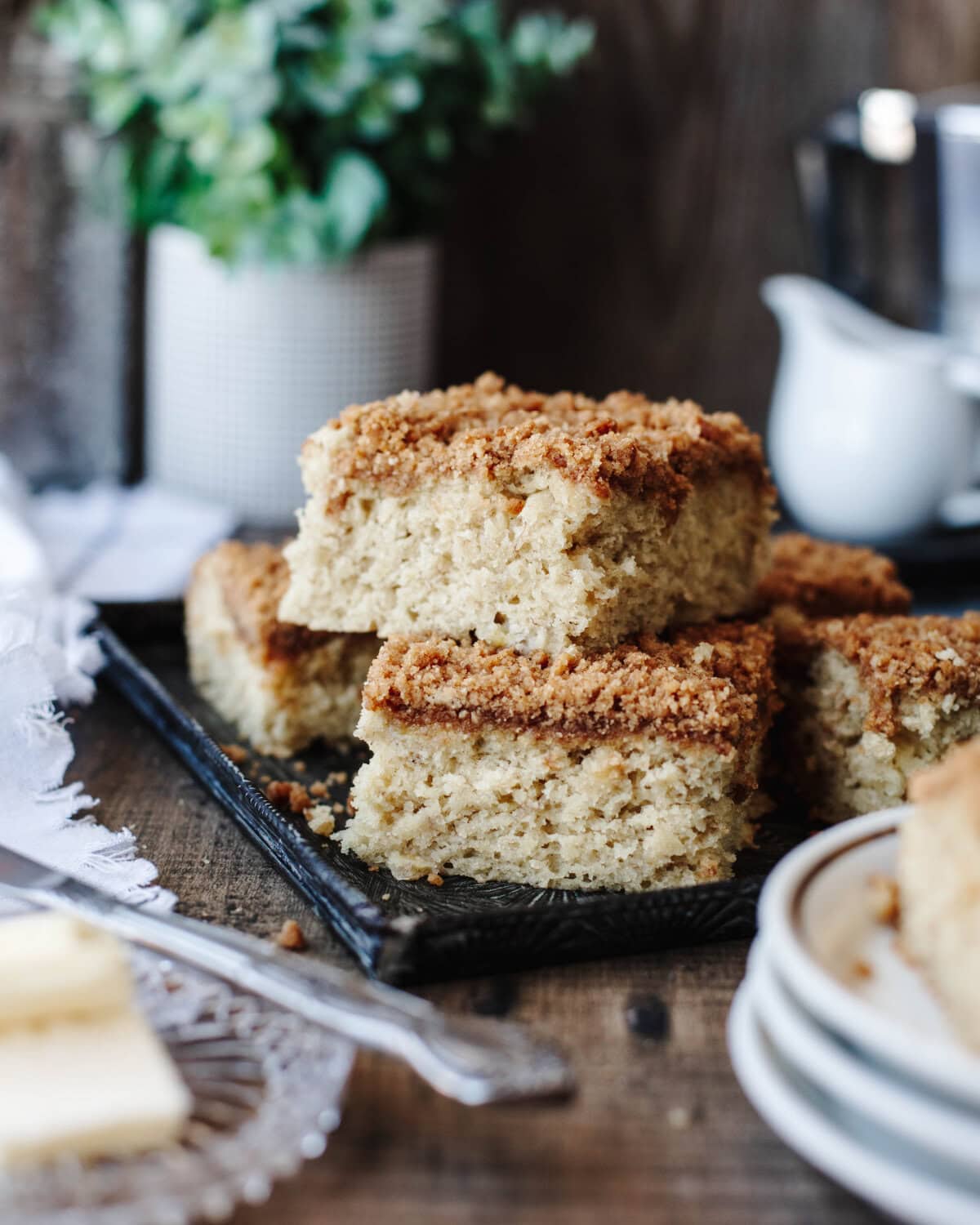 Pieces of banana coffee cake stacked on a black serving tray.