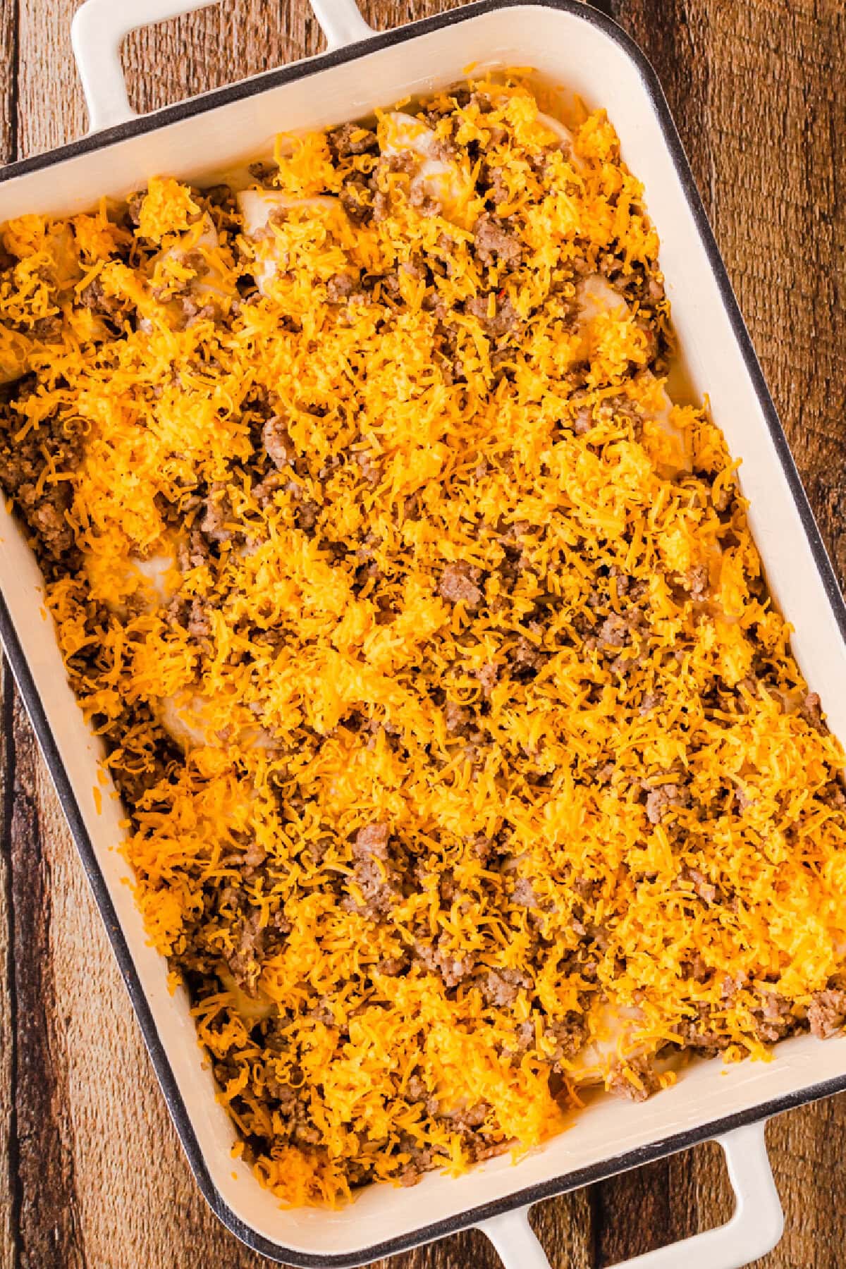 An egg mixture poured on top of quartered biscuits and crumbled sausage.