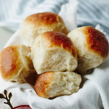 Bread machine dinner rolls stacked in a basket ready to serve.