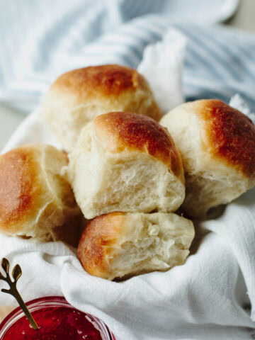 Bread machine dinner rolls stacked in a basket ready to serve.