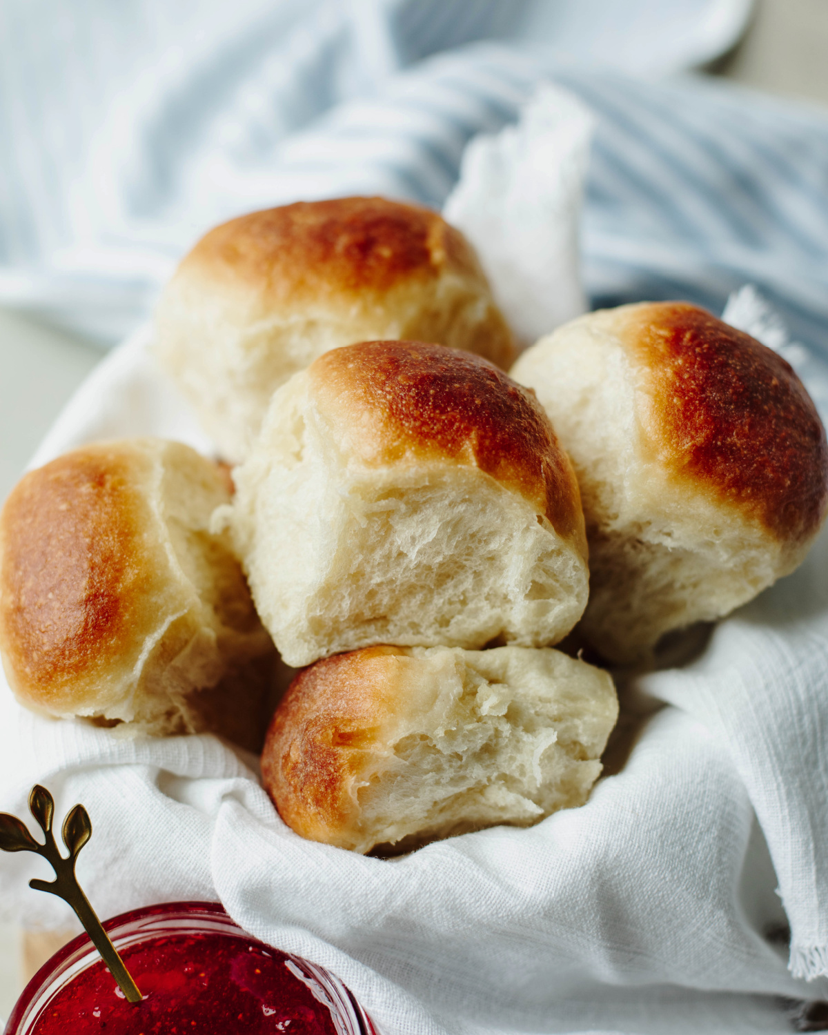 Bread machine dinner rolls stacked in a basket ready to serve.