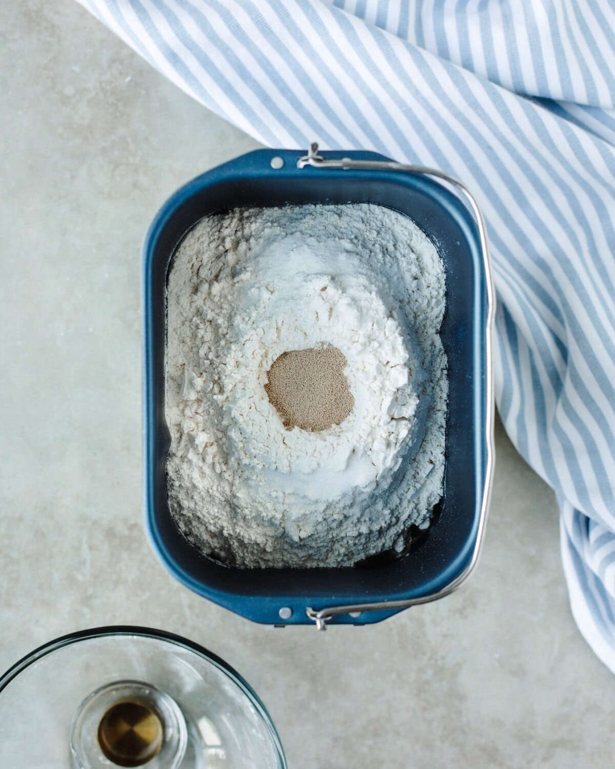 Ingredients added to a bread machine pan and yeast placed in a well in the center of the pan.