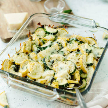 Baked cheesy zucchini casserole in a glass 8x8 baking pan.