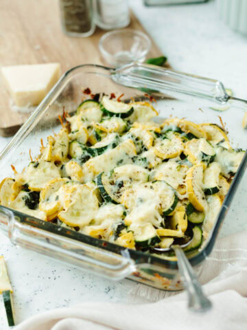 Baked cheesy zucchini casserole in a glass 8x8 baking pan.