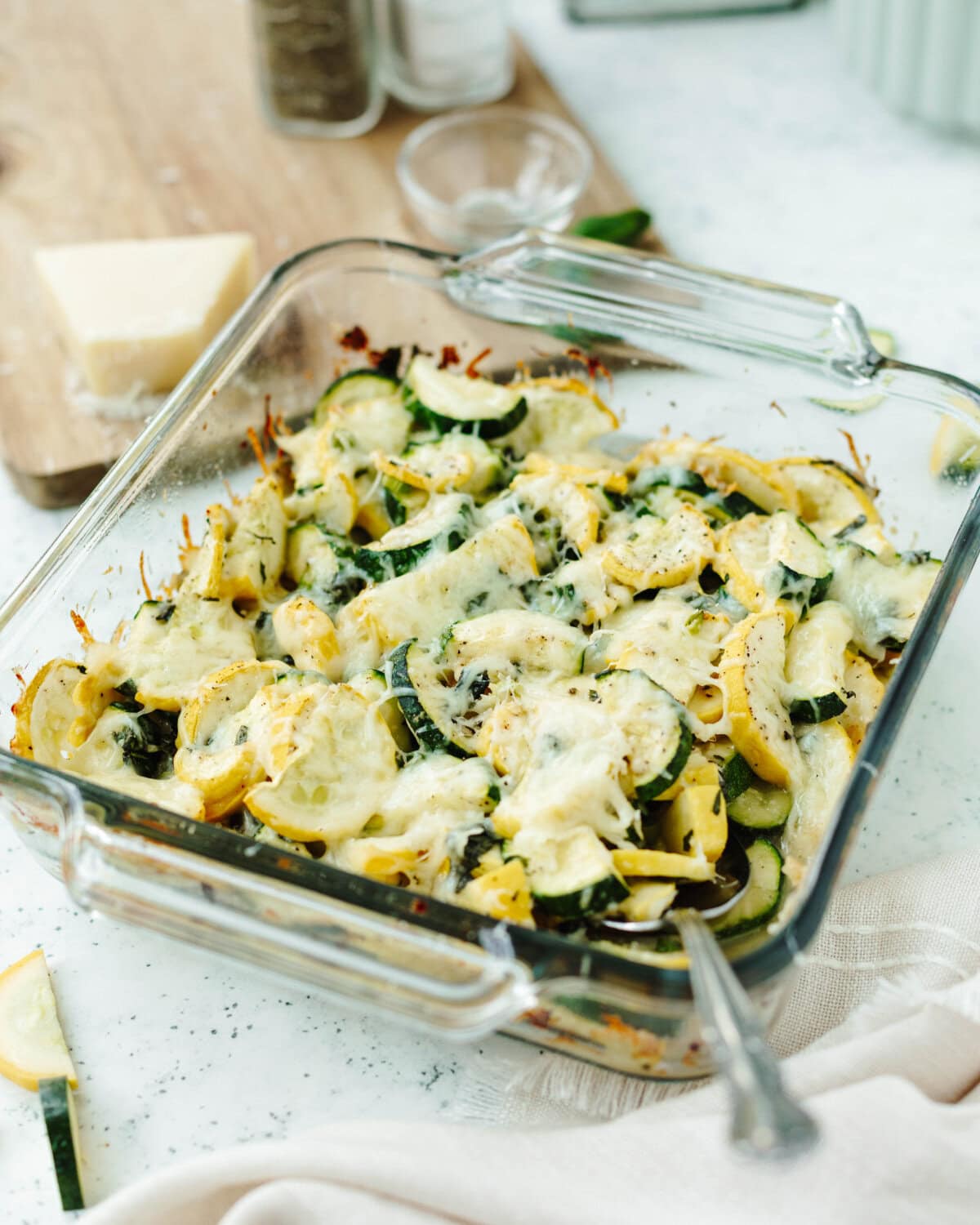 Baked cheesy zucchini casserole in a glass 8x8 baking pan.