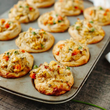 Baked chicken pot pie muffins fresh from the oven in a muffin pan.