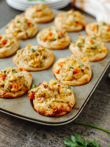 Baked chicken pot pie muffins fresh from the oven in a muffin pan.