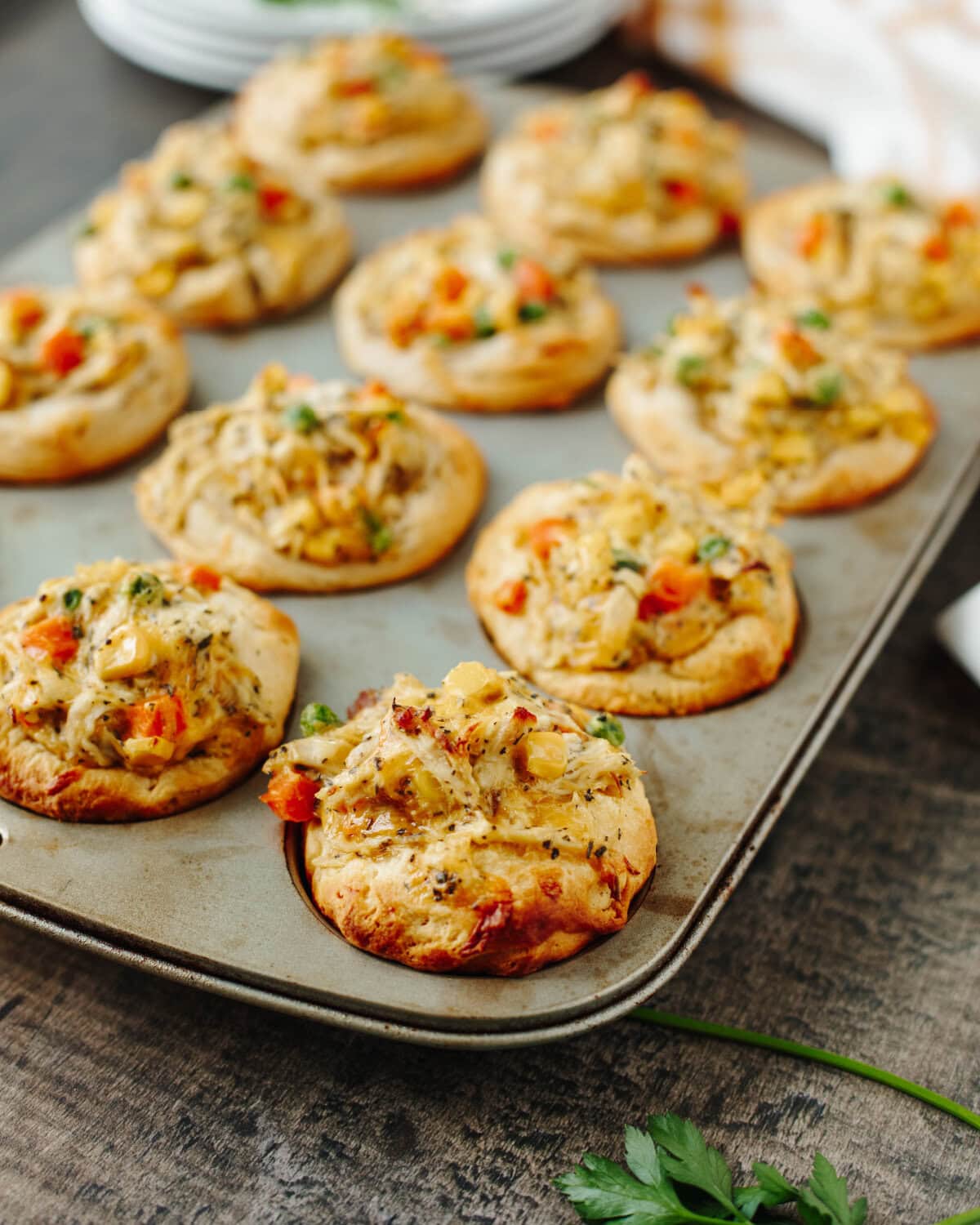Baked chicken pot pie muffins fresh from the oven in a muffin pan.