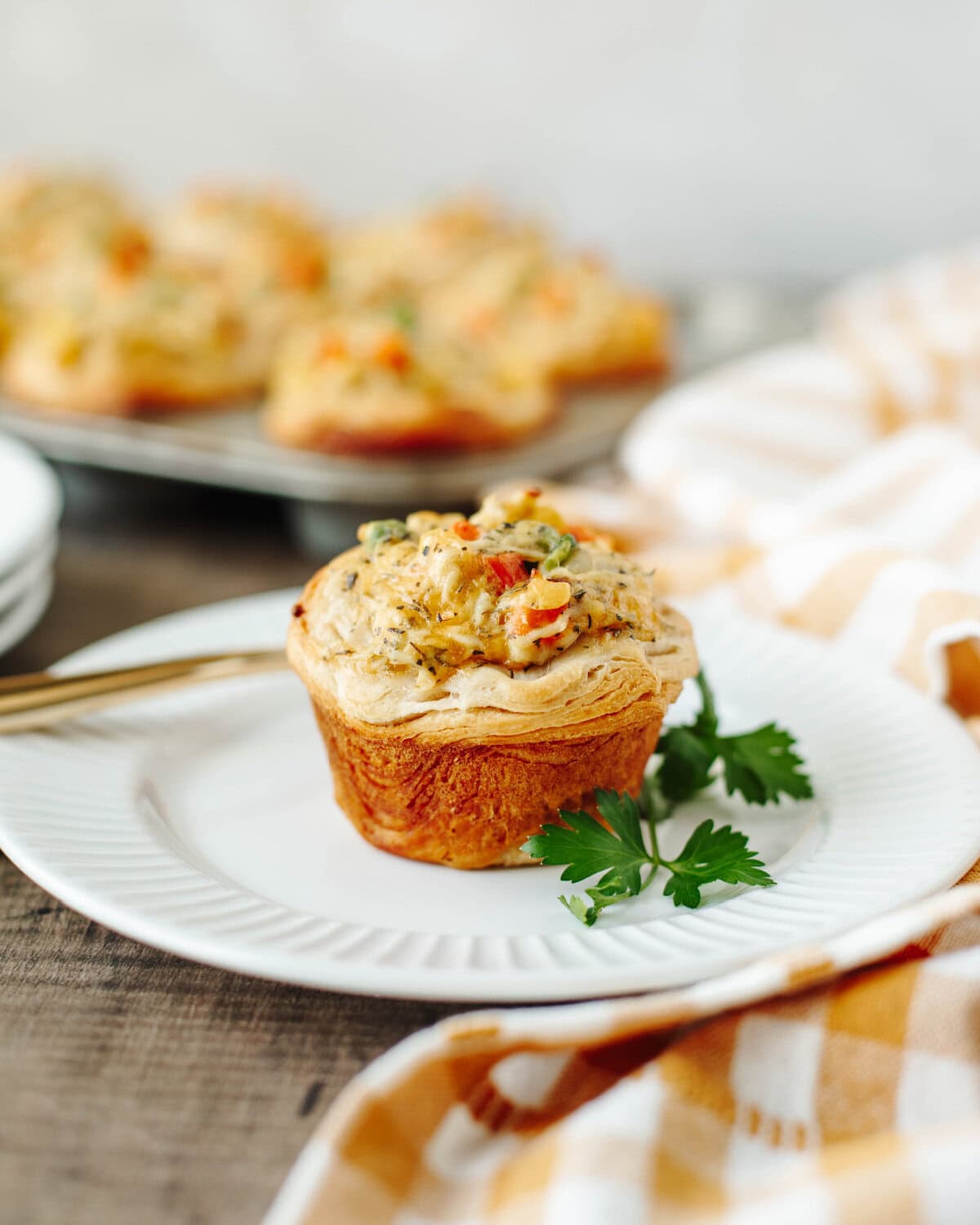 A chicken pot pie muffin on a white plate ready to serve and enjoy.