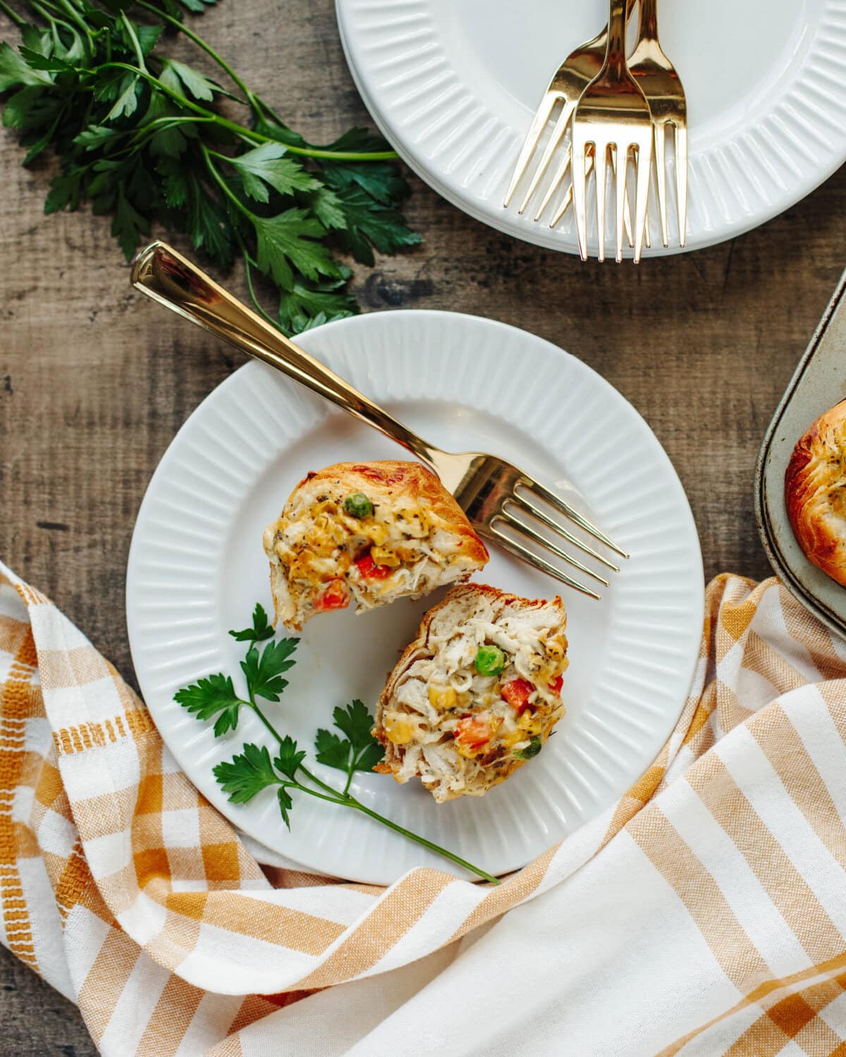 A chicken pot pie muffin sliced in half to show the vegetables and chicken mixture.