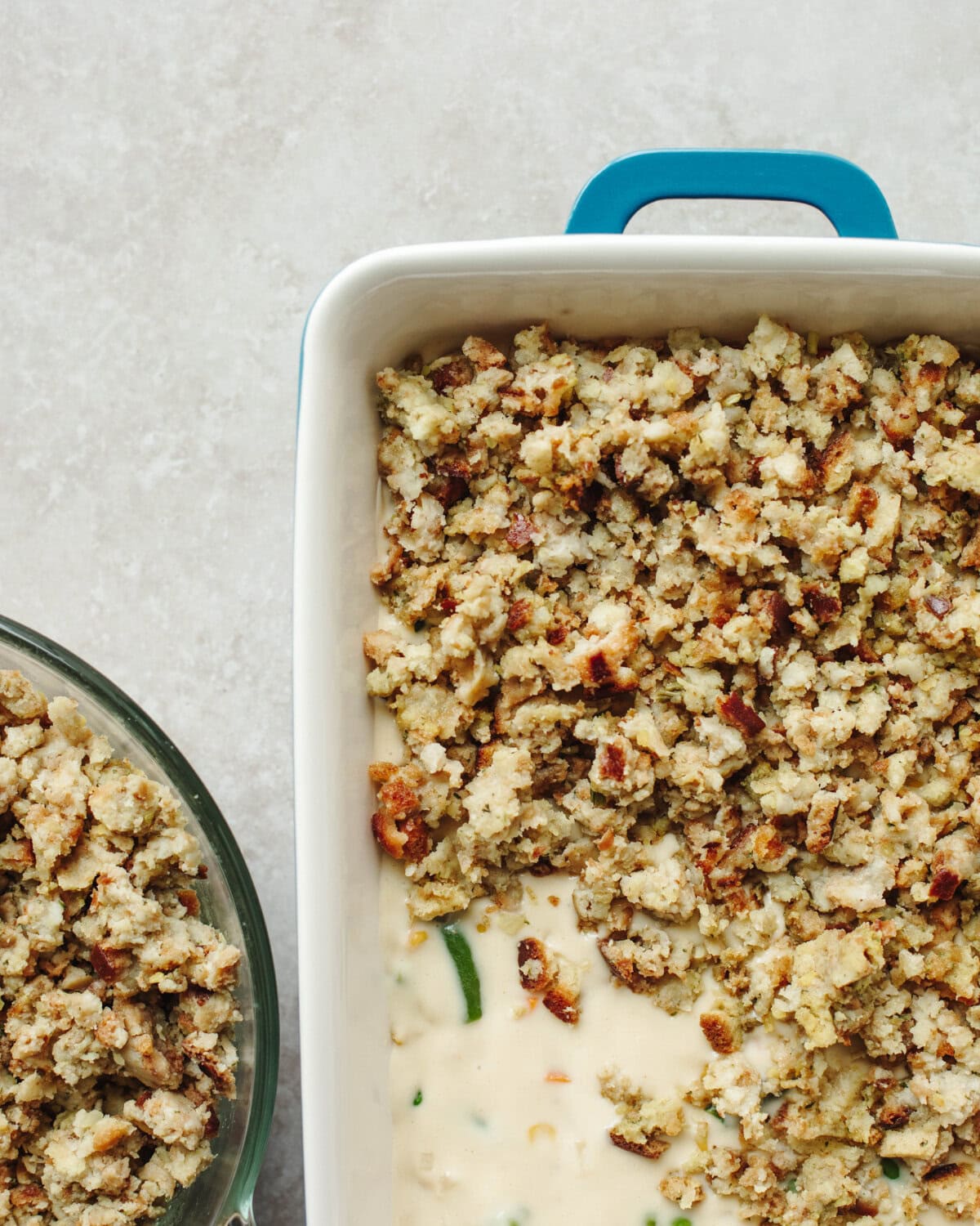 Stovetop stuffing mix spread evenly on top of mixed vegetables and diced chicken in a baking dish.