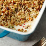 Baked stuffing topped chicken pot pie in a blue ceramic baking dish.