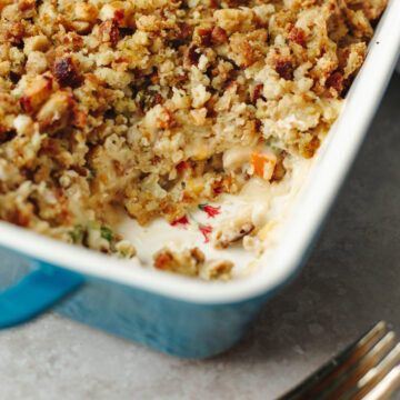 Baked stuffing topped chicken pot pie in a blue ceramic baking dish.