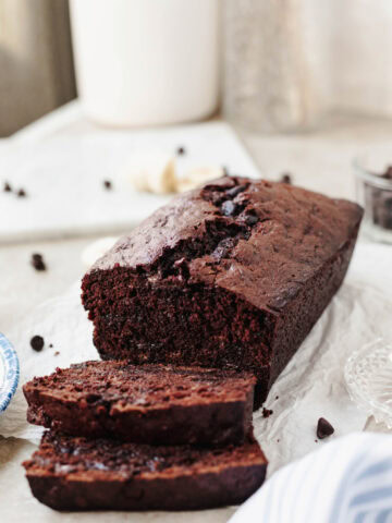 A sliced loaf of double chocolate banana bread on a serving platter.