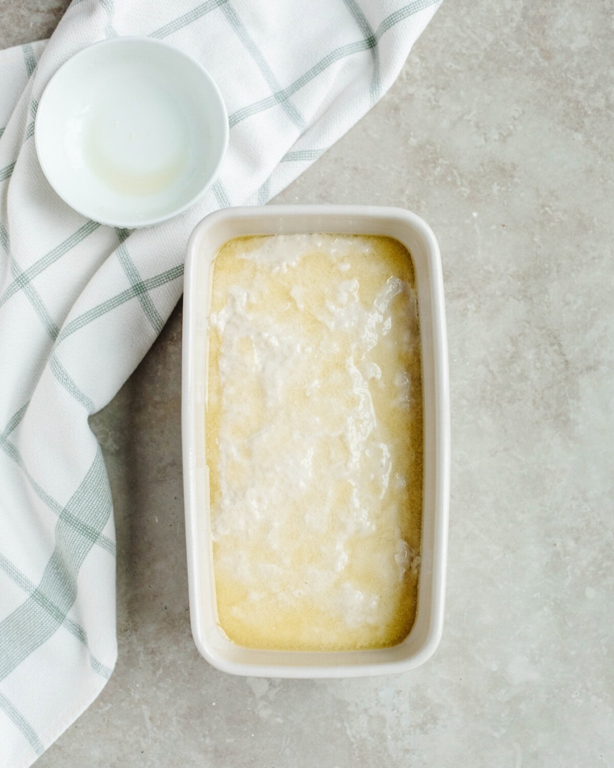 Melted butter spread on top of batter in a prepared loaf pan.