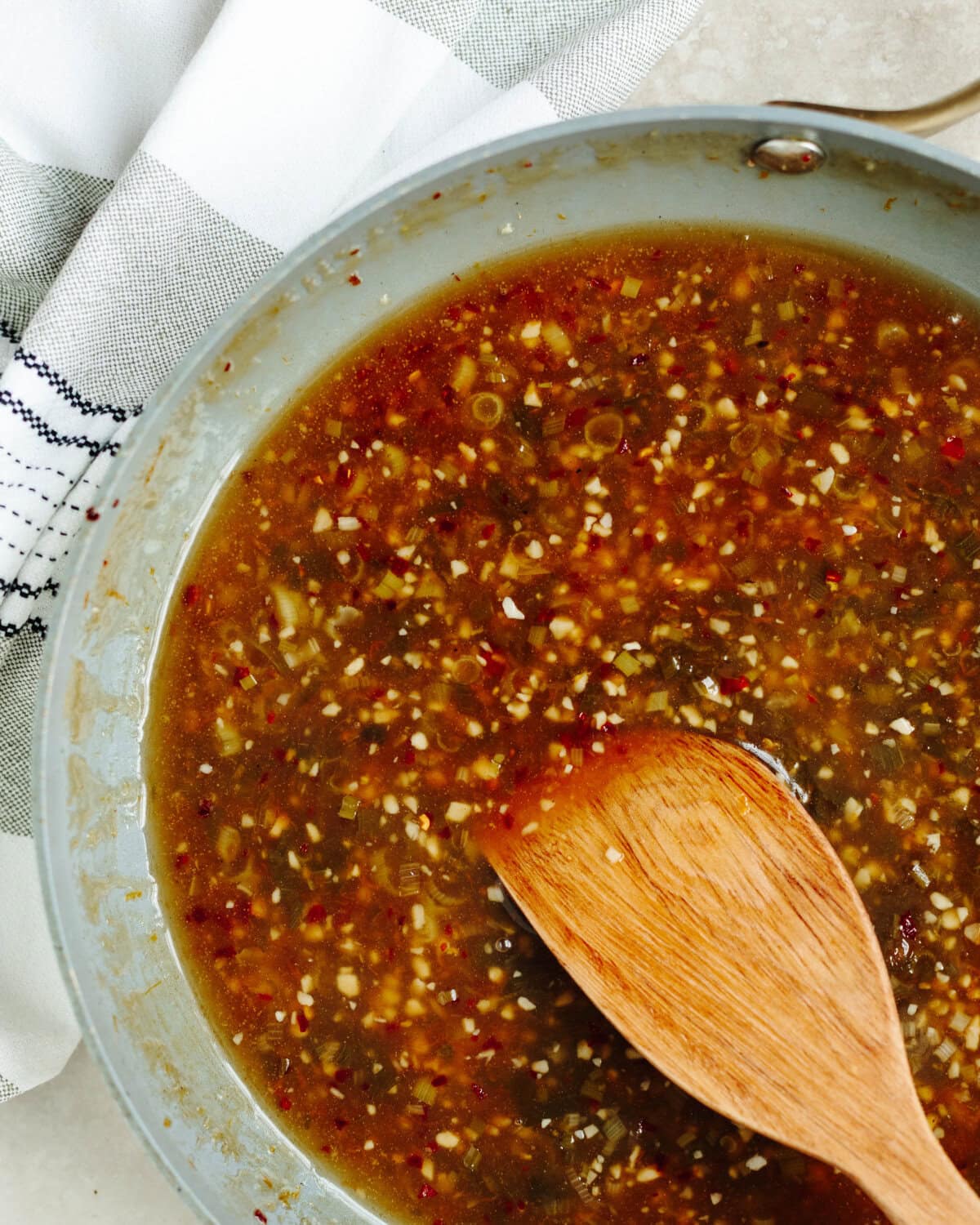 Rice wine, orange sauce, and cornstarch slurry added to a skillet.